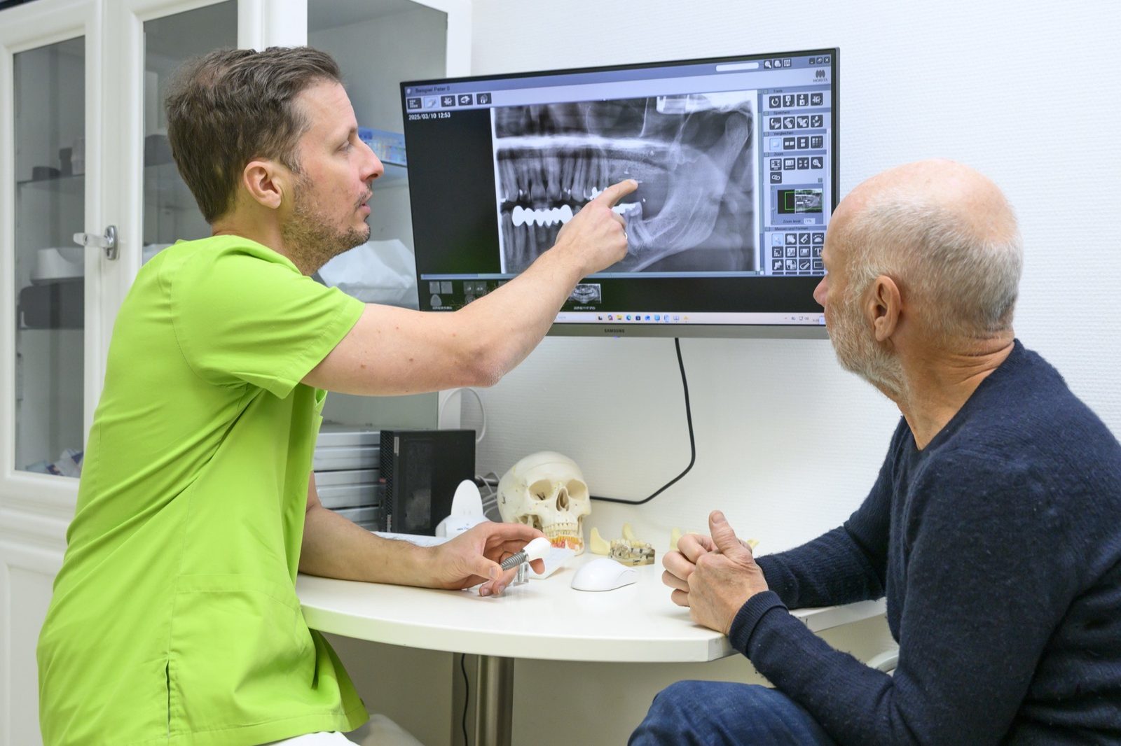 Dr. Ansgar Hergt erklaert einem Patienten den DVT-Befund - Planung der Weisheitszahnentfernung in Templin